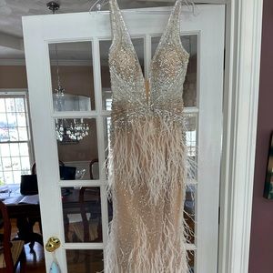 Fun Jovani nude colored dress with white feathers and gemstones throughout.